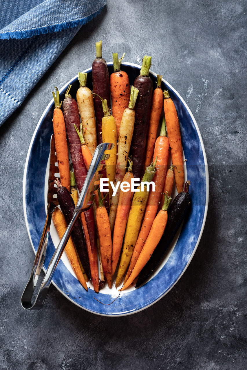 Top down view of an oval serving dish filled with roasted rainbow carrots.