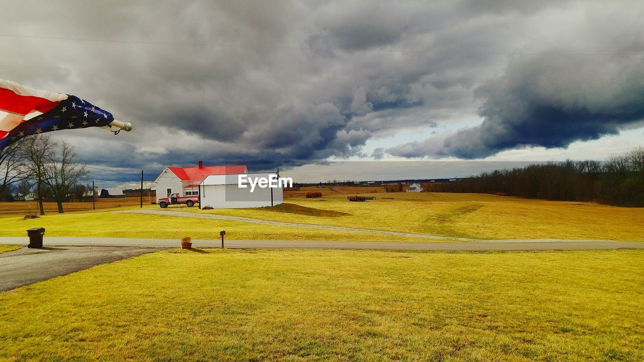 TRANQUIL VIEW OF GRASSY FIELD AGAINST CLOUDY SKY