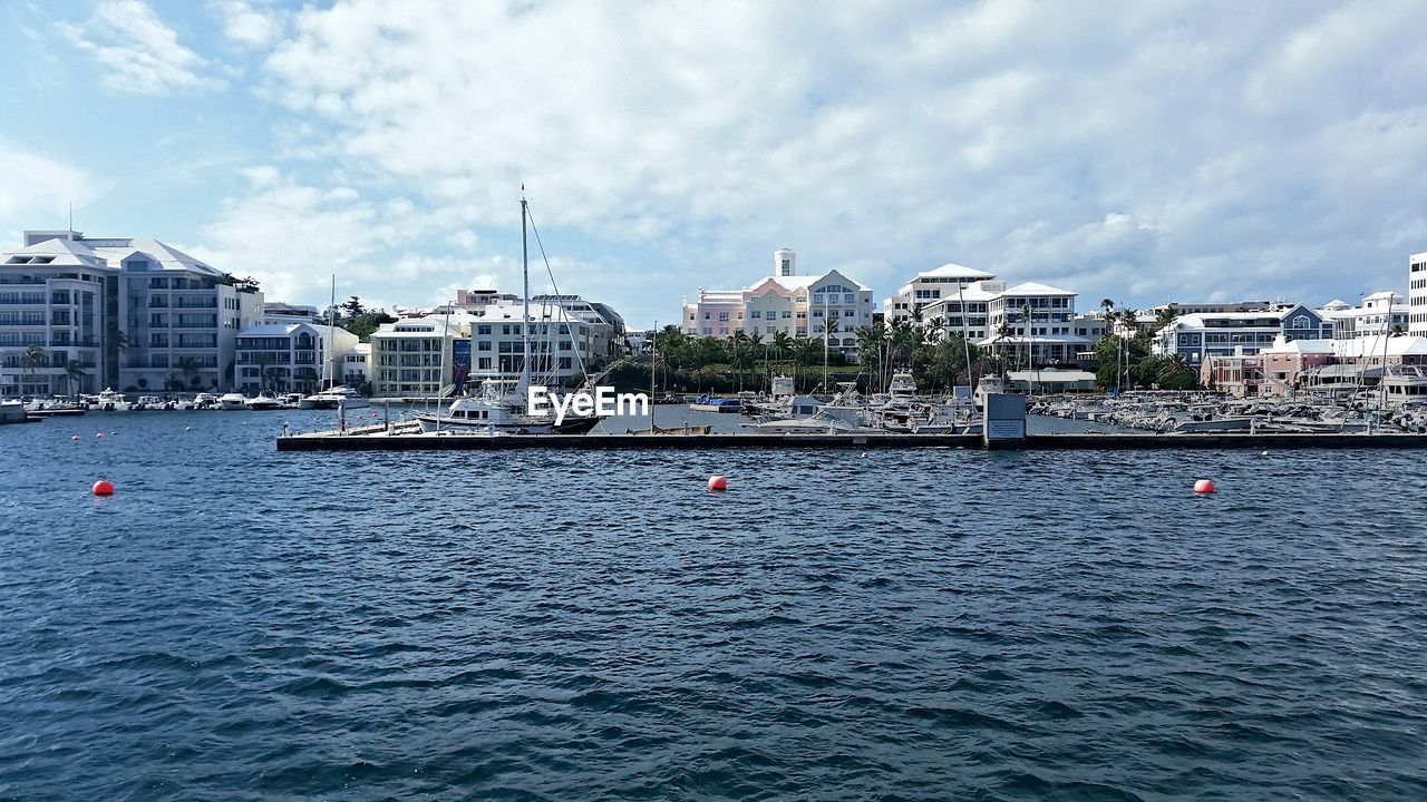 Boats in river with city in background