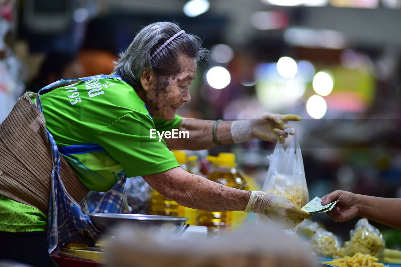 SIDE VIEW OF A MAN HOLDING ICE CREAM CONE