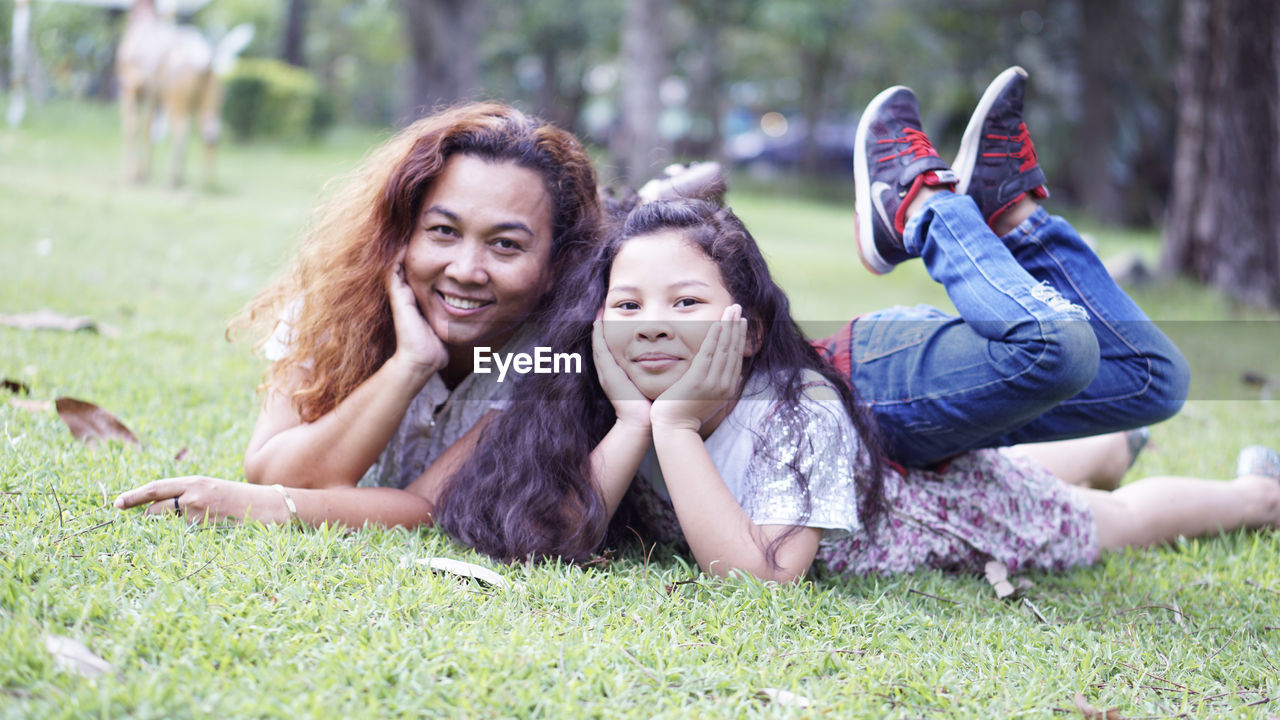Portrait of smiling family lying on grass in park