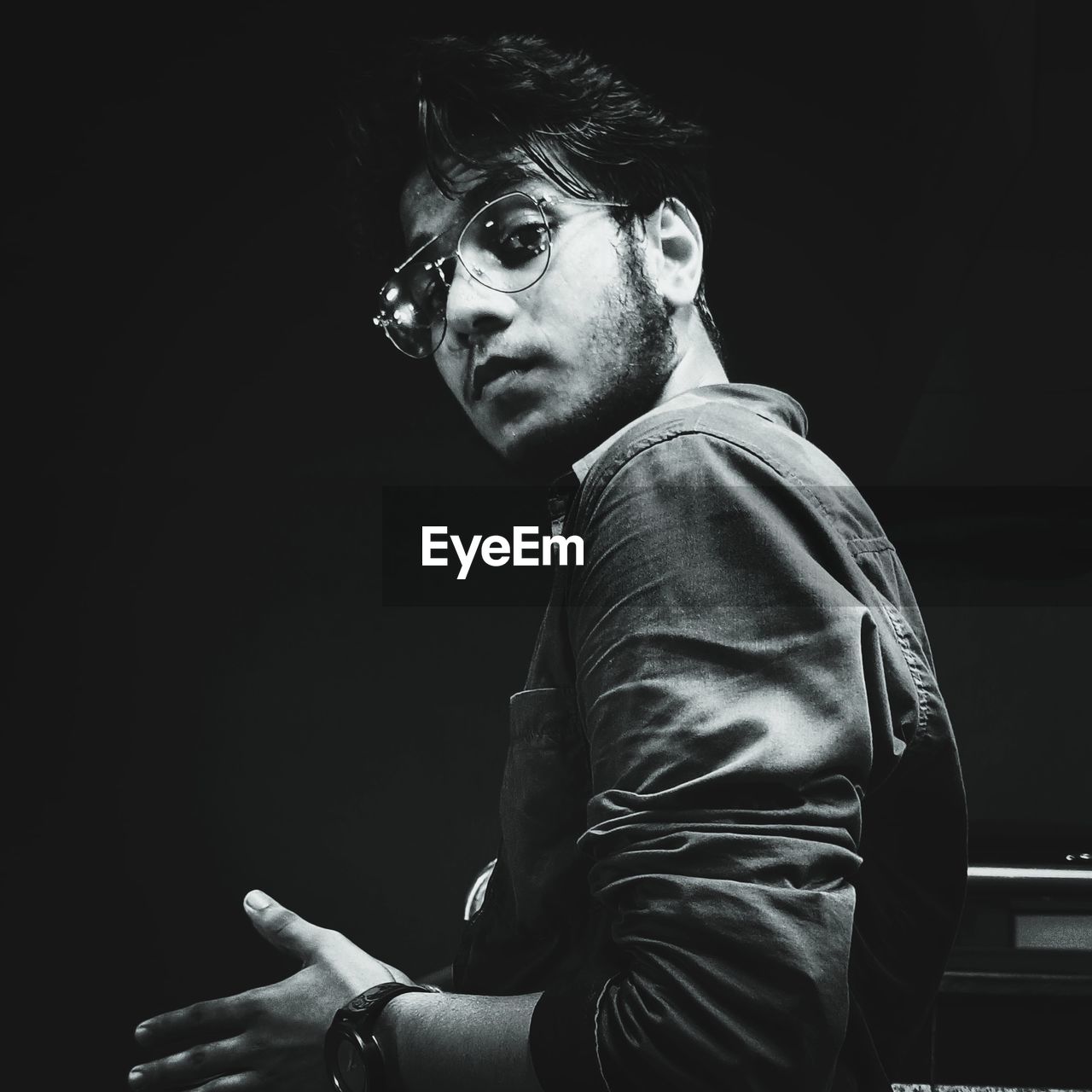 portrait of young man sitting in darkroom