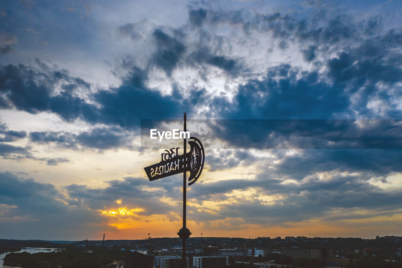 LOW ANGLE VIEW OF TEXT ON BUILDING AT SUNSET