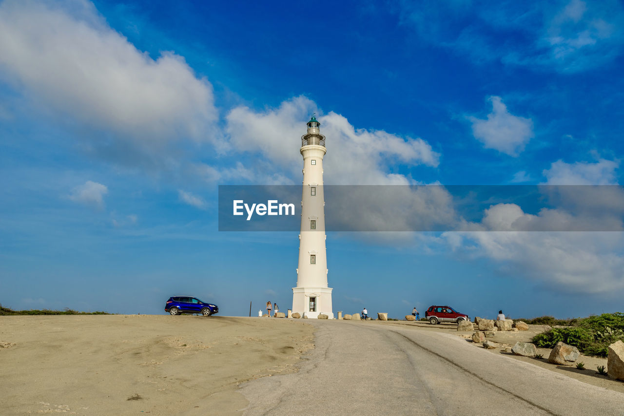 LIGHTHOUSE BY ROAD AGAINST SKY