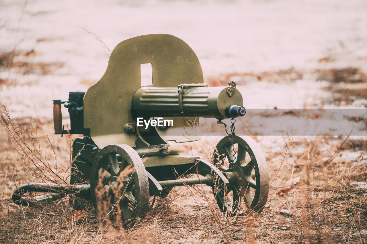 Close-up of old machine gun on land