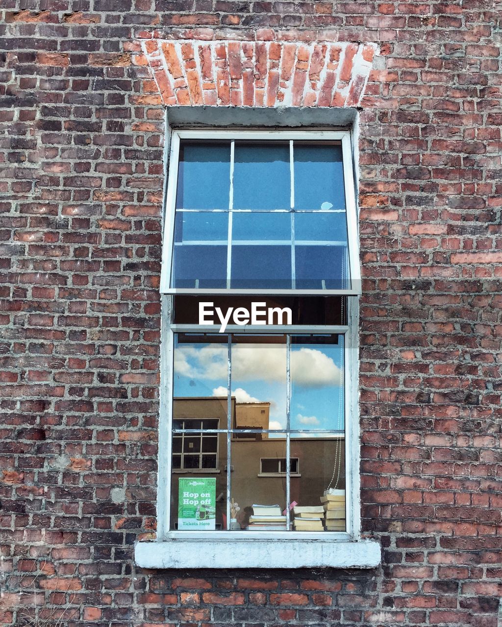 LOW ANGLE VIEW OF WINDOWS ON BRICK WALL OF BUILDING