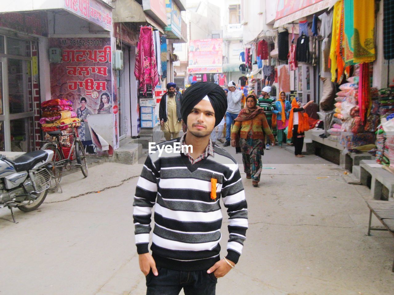 WOMAN STANDING ON STREET MARKET IN CITY