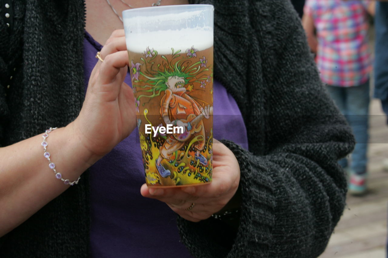 CLOSE-UP OF CROPPED HAND HOLDING ICE CREAM