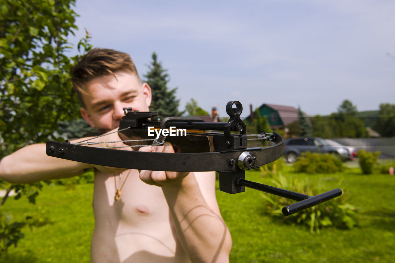 Close-up of man holding crossbow