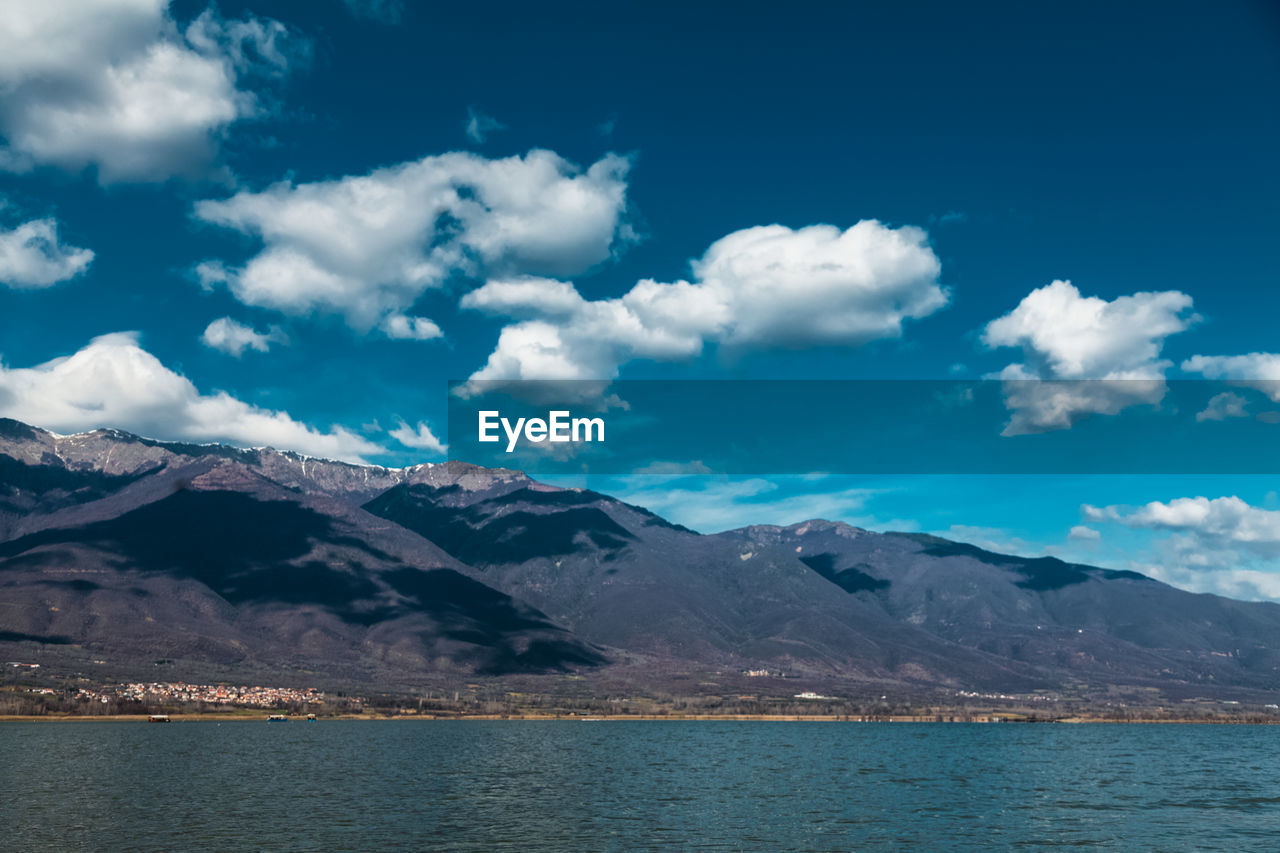 Scenic view of sea and mountains against sky