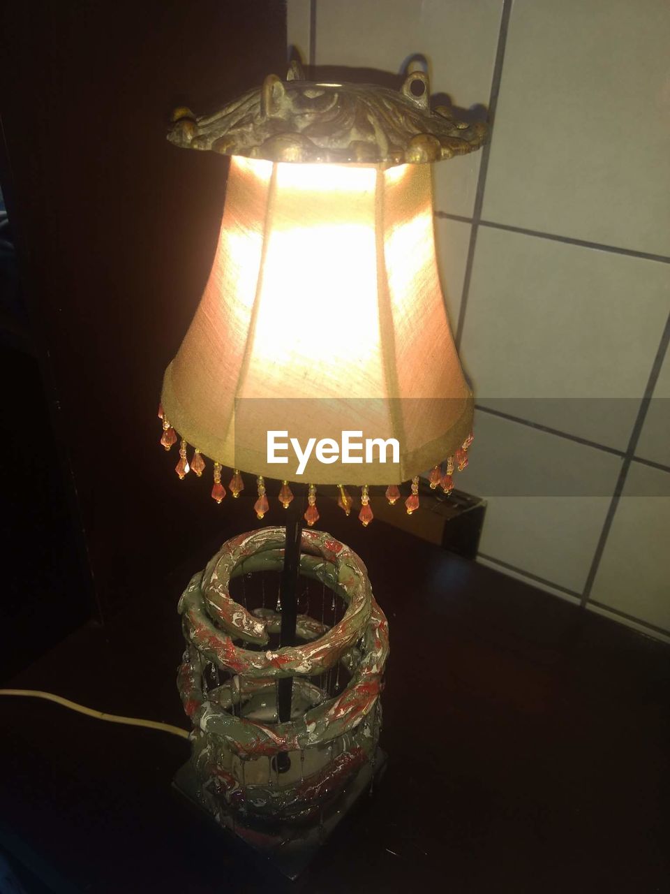ILLUMINATED LAMP HANGING ON TABLE