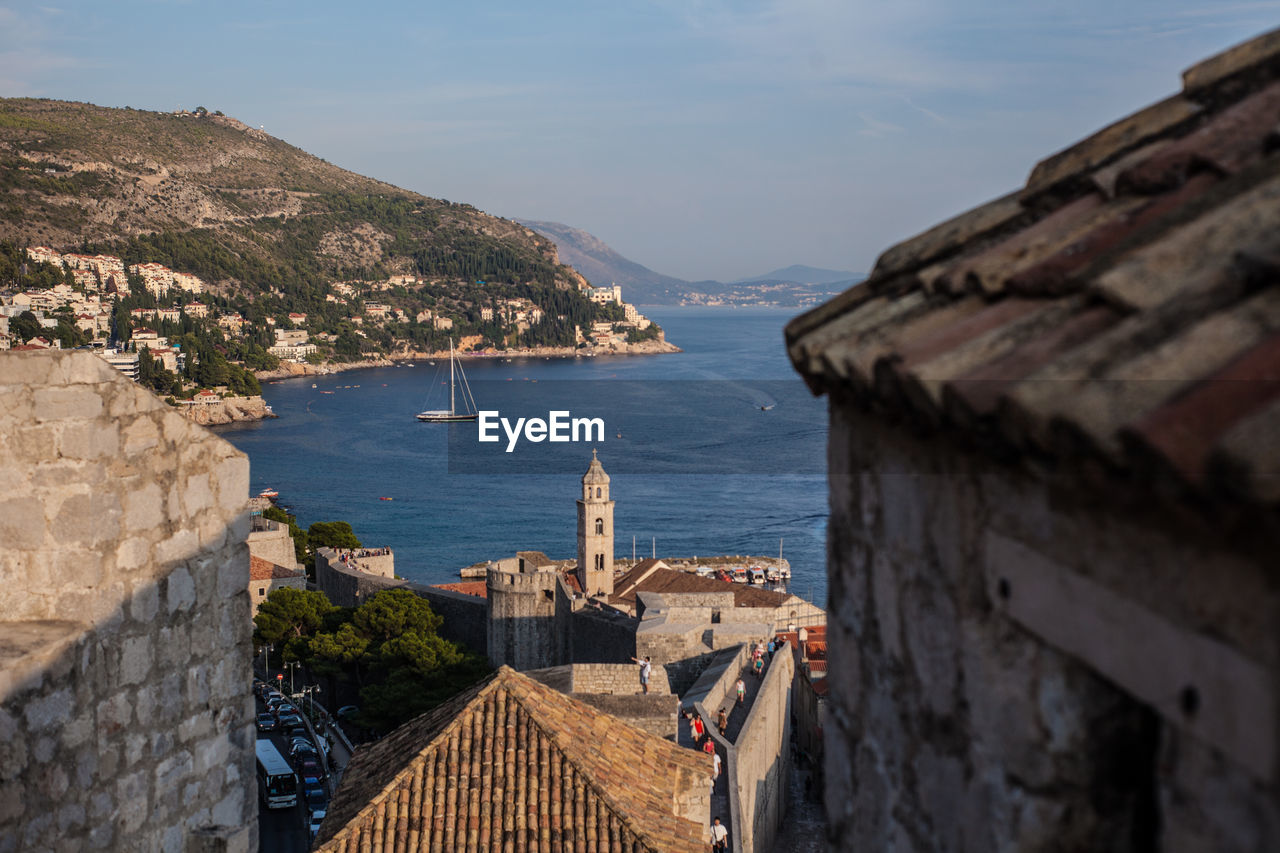 High angle view of townscape by sea against sky