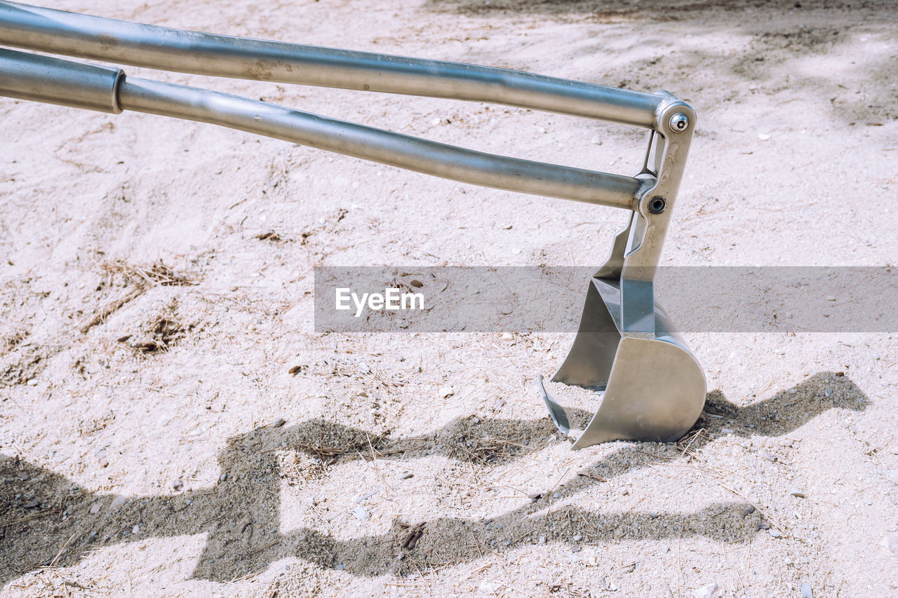 HIGH ANGLE VIEW OF METALLIC STRUCTURE ON SAND