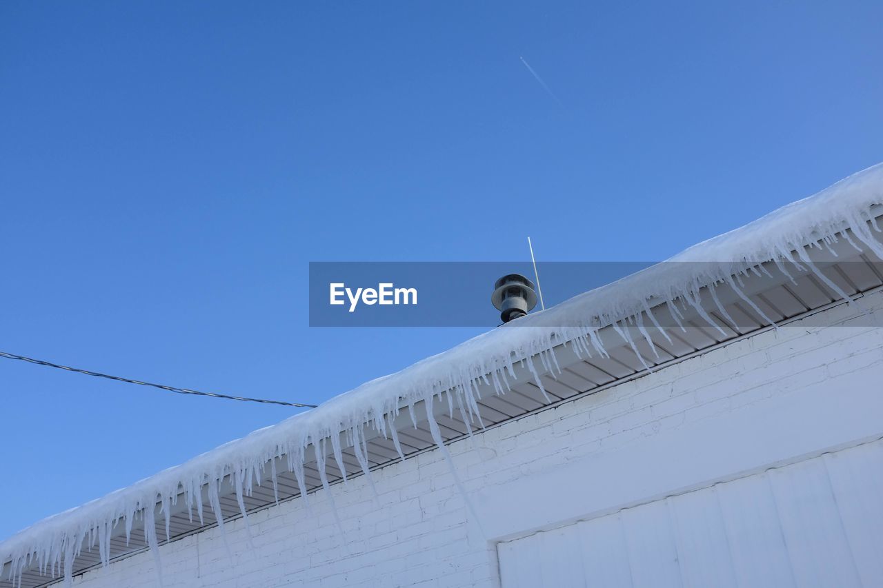 blue, sky, architecture, built structure, clear sky, low angle view, day, building exterior, nature, no people, copy space, roof, outdoors, snow, white, technology, wing, wind, travel