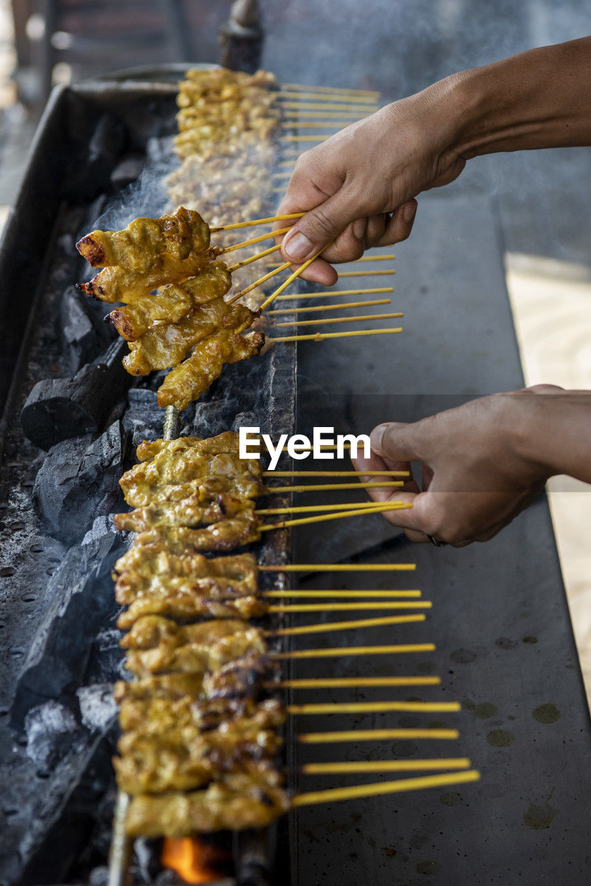 cropped image of man preparing food on barbecue grill