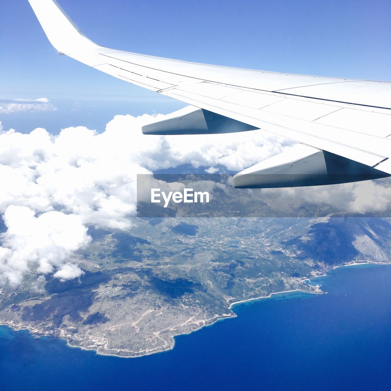 Aerial view of aircraft wing over landscape against sky