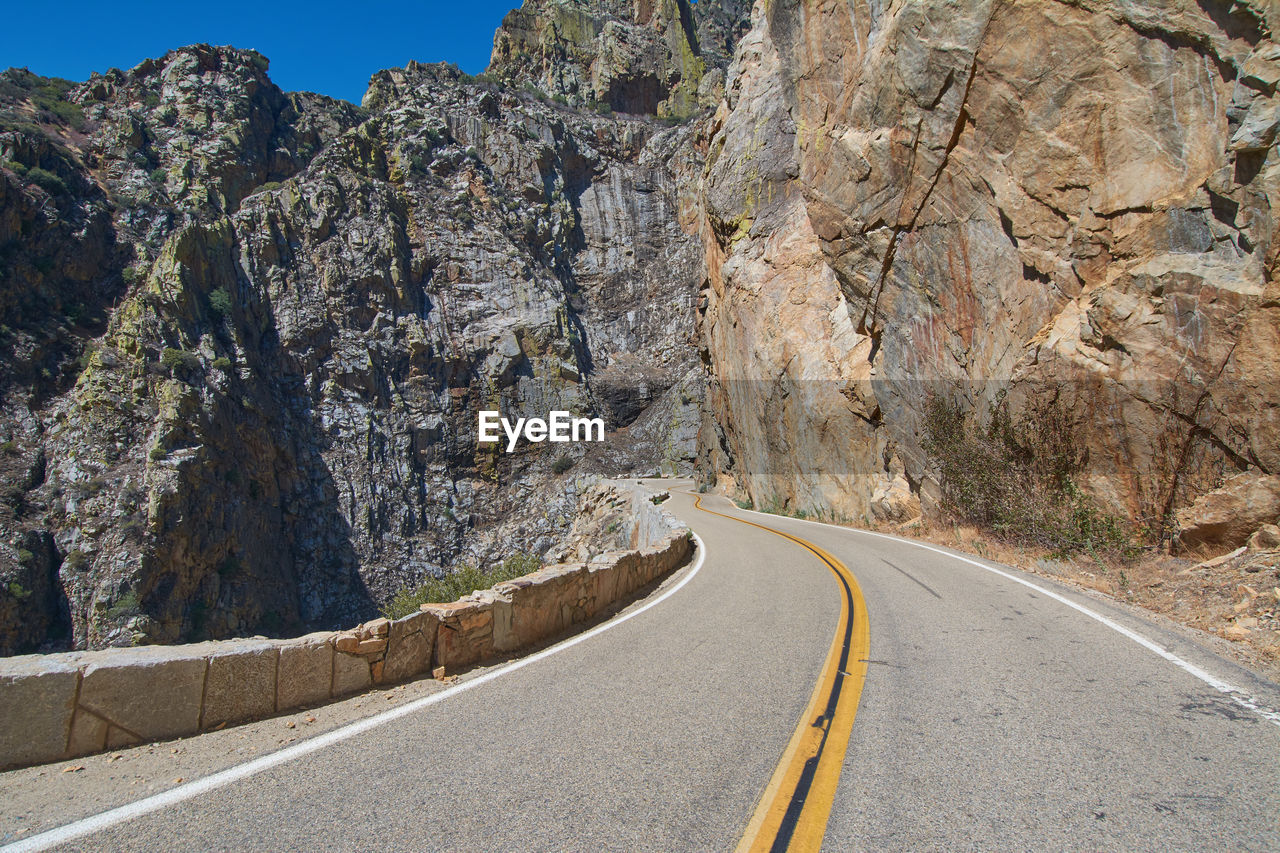 Road amidst rocky mountains against sky