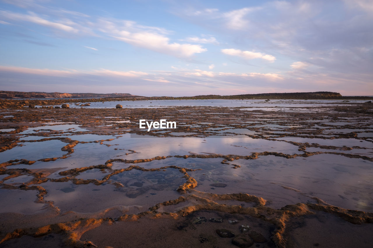 Scenic view of beach against sky during sunset