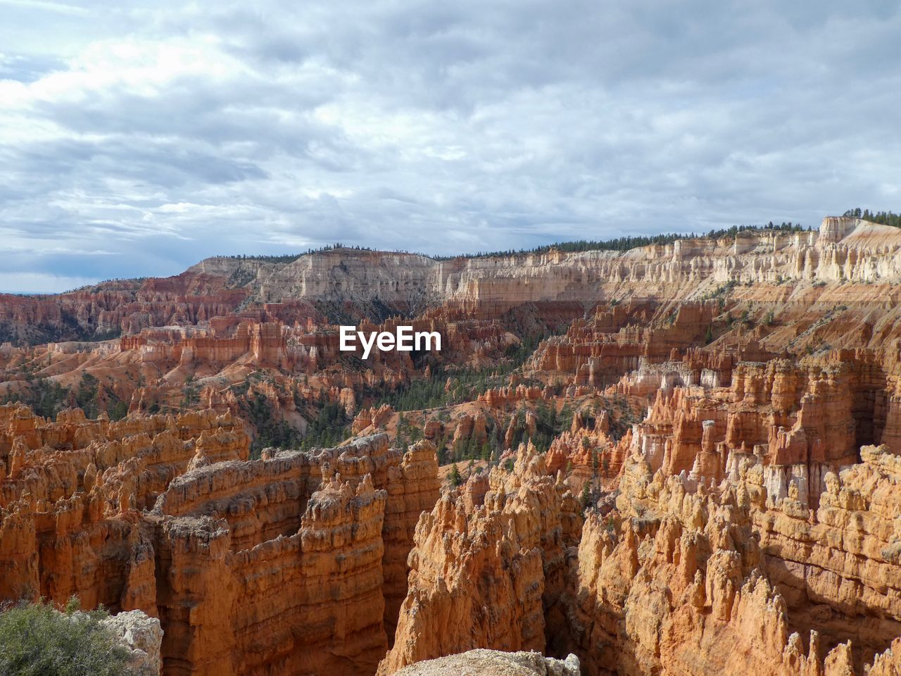 Scenic view of rock formations against cloudy sky