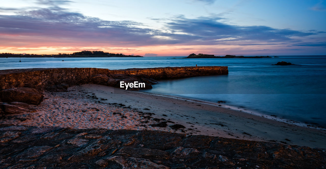 Scenic view of the bay of roscoff and the island of batz at sunset