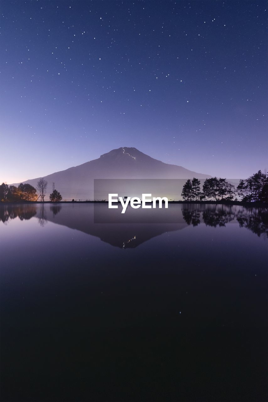 Scenic view of lake against sky at night