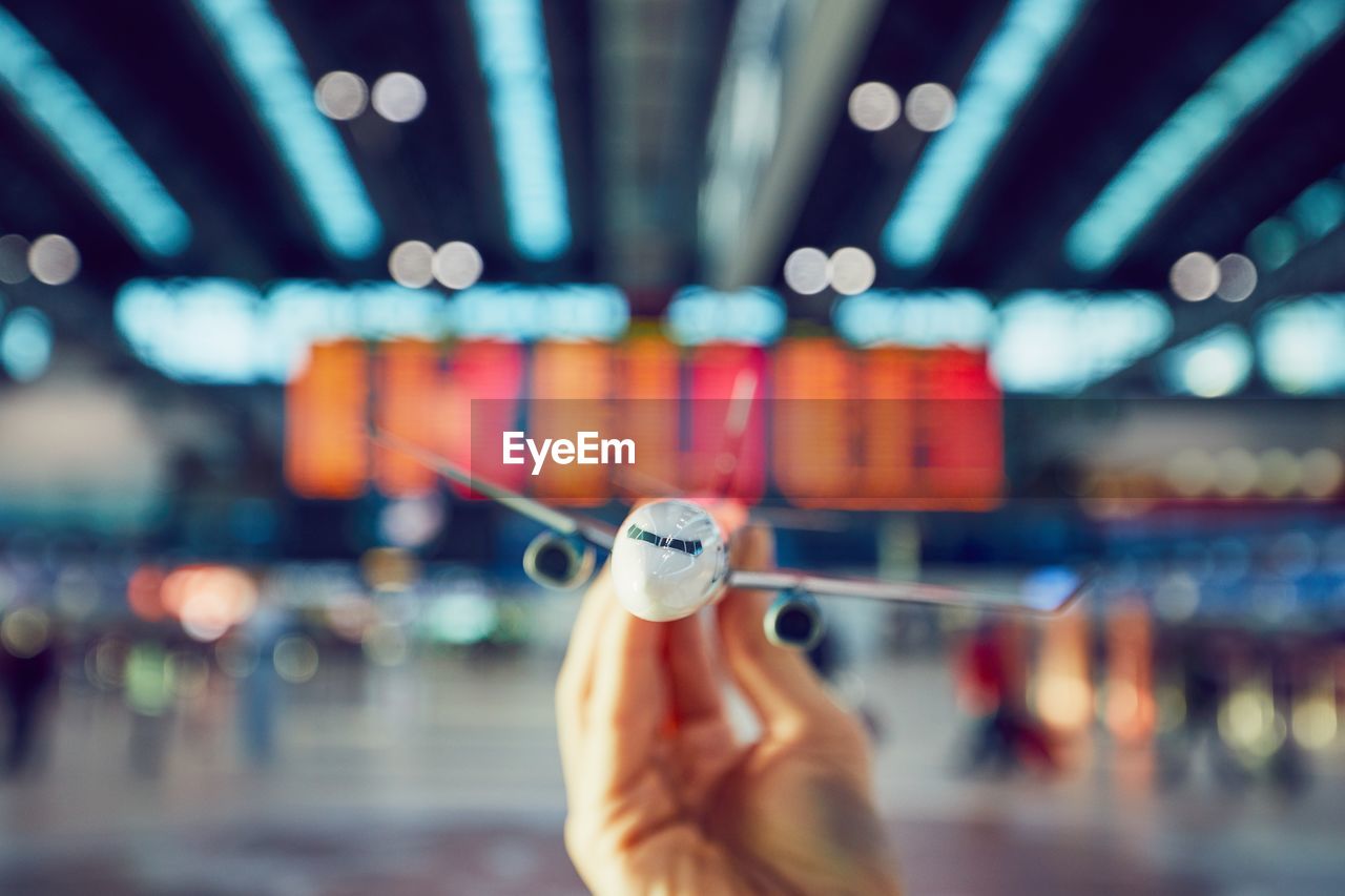 Cropped hand of person holding toy airplane