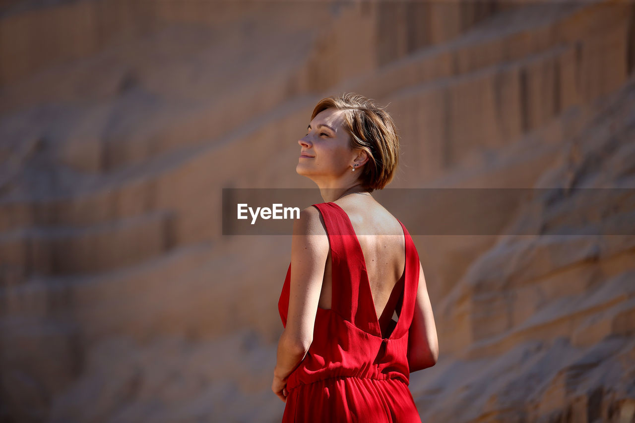 Young woman standing against rock formations