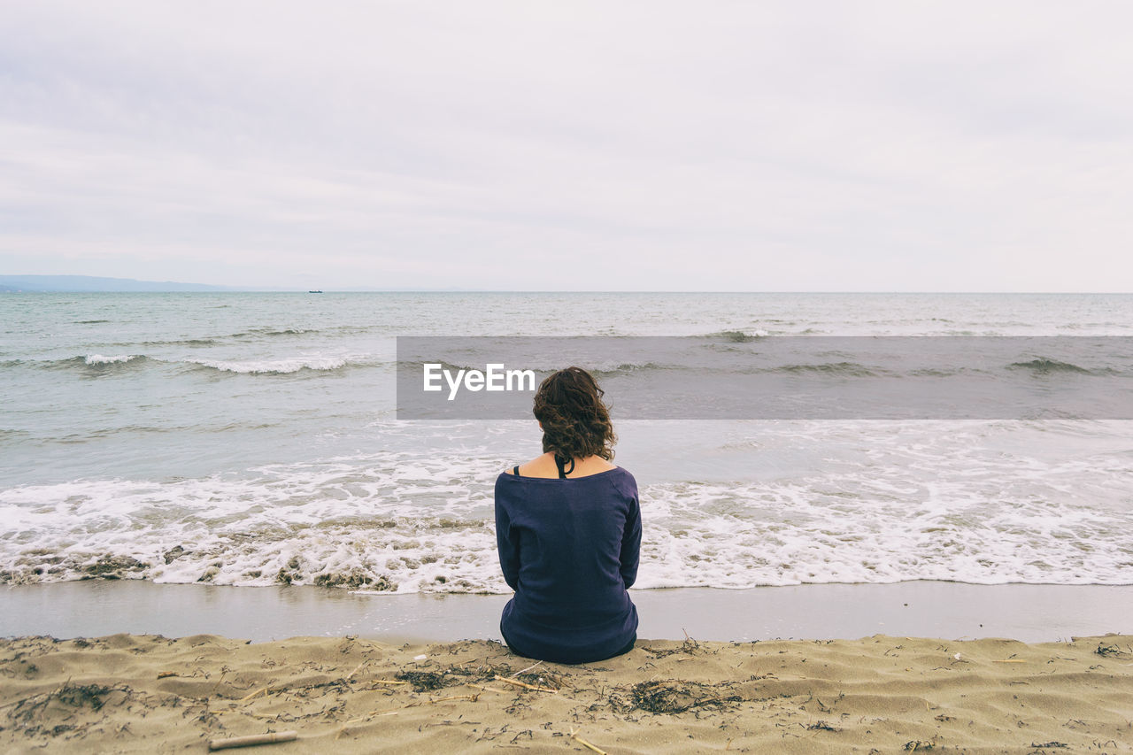 Rear view of woman looking at sea against sky