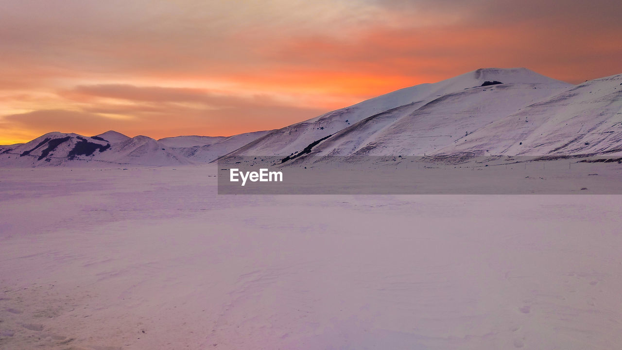 Scenic view of snowcapped mountain against sky during sunset