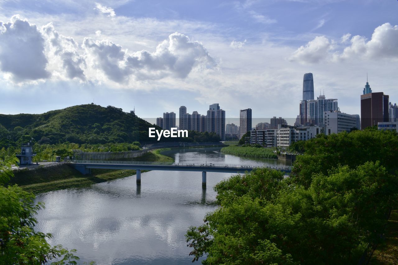 View of city by river against sky