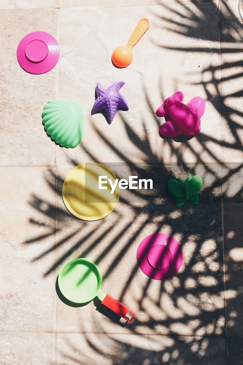 High angle view of plastic toys on floor during sunny day