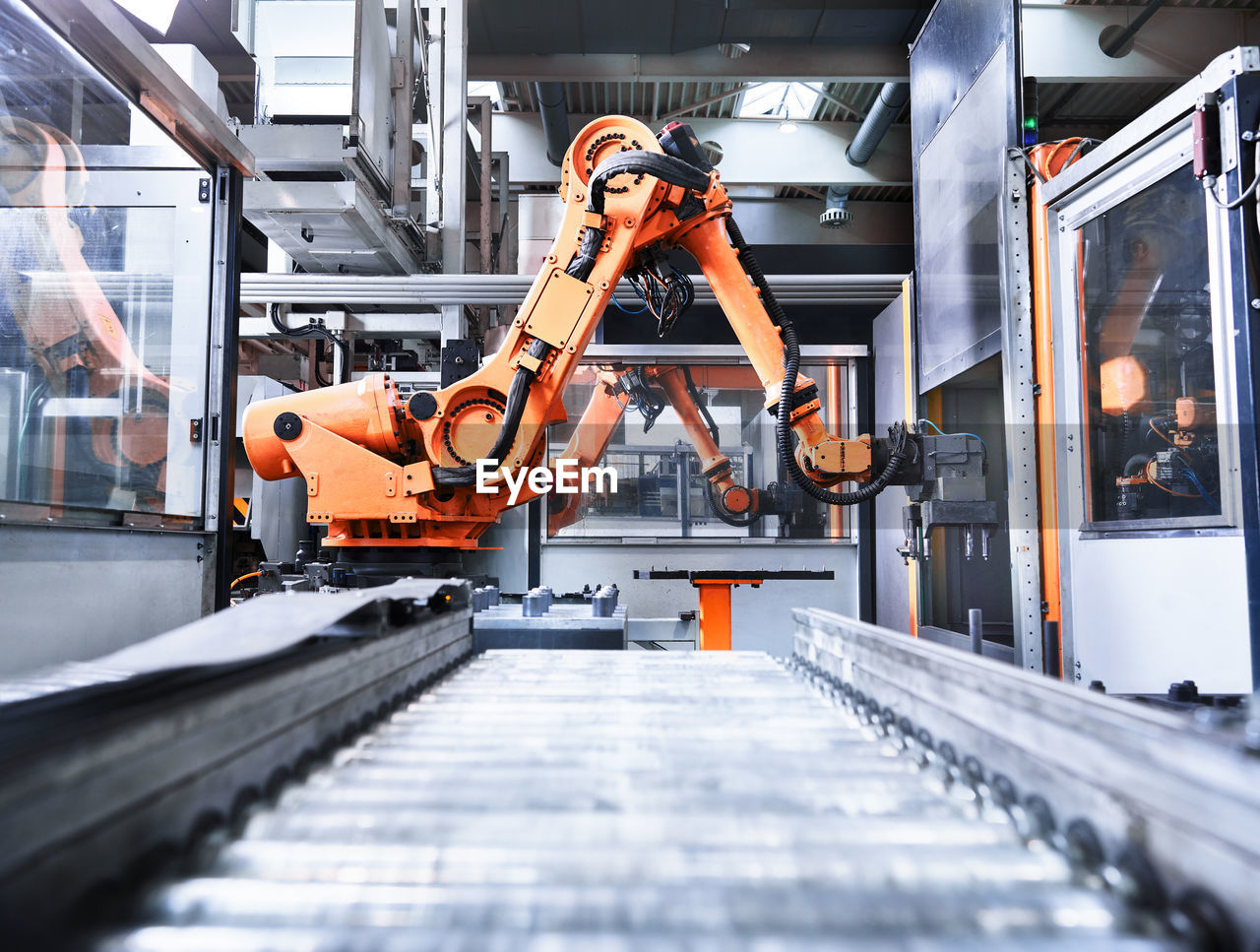 Robotic arm over conveyor belt in factory