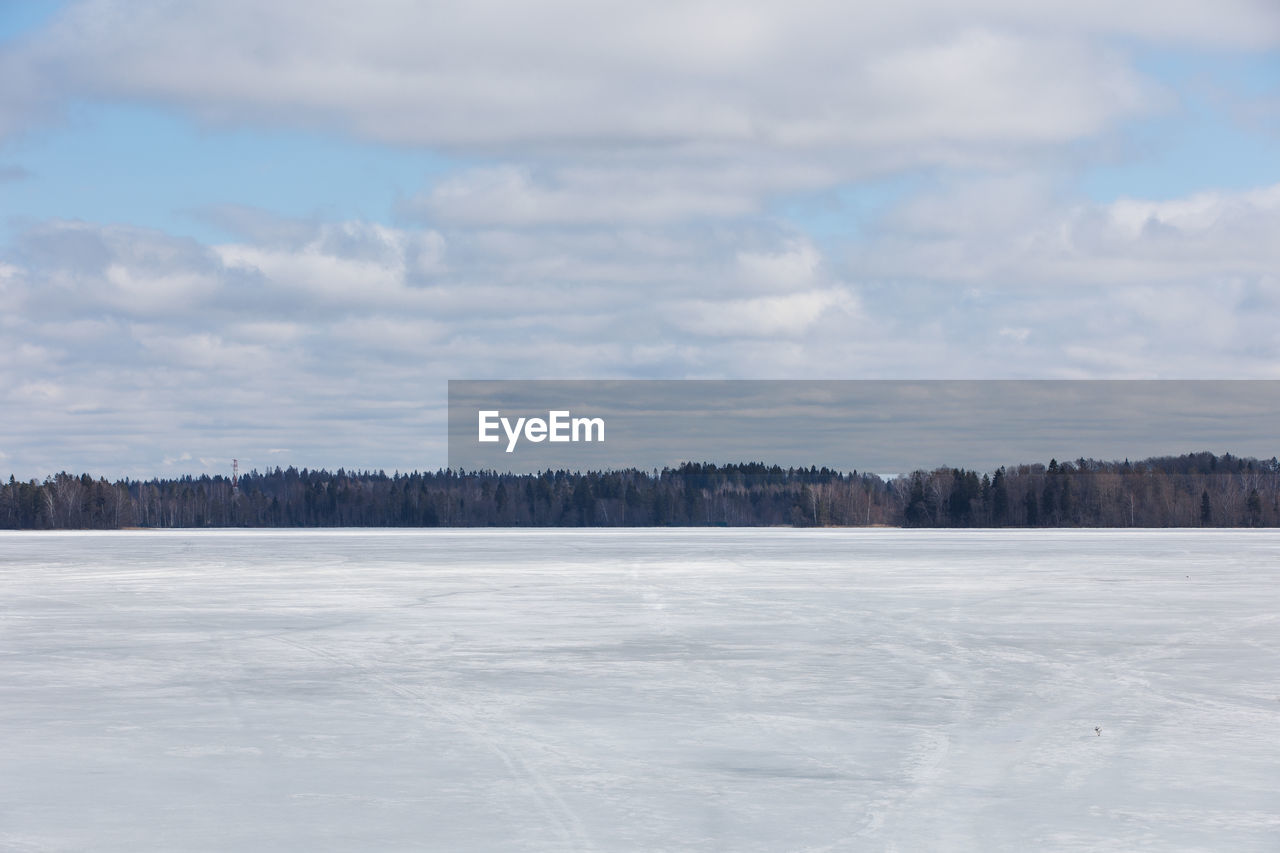 Scenic view of snow covered field against sky