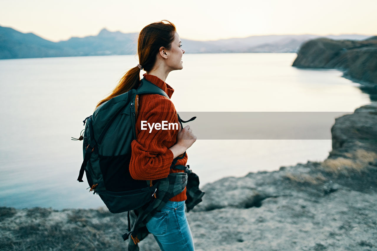 YOUNG WOMAN LOOKING AT SEA