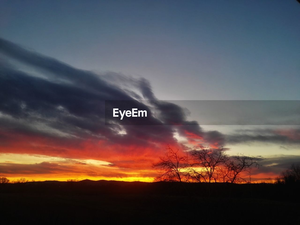 SCENIC VIEW OF SILHOUETTE FIELD AGAINST SKY DURING SUNSET