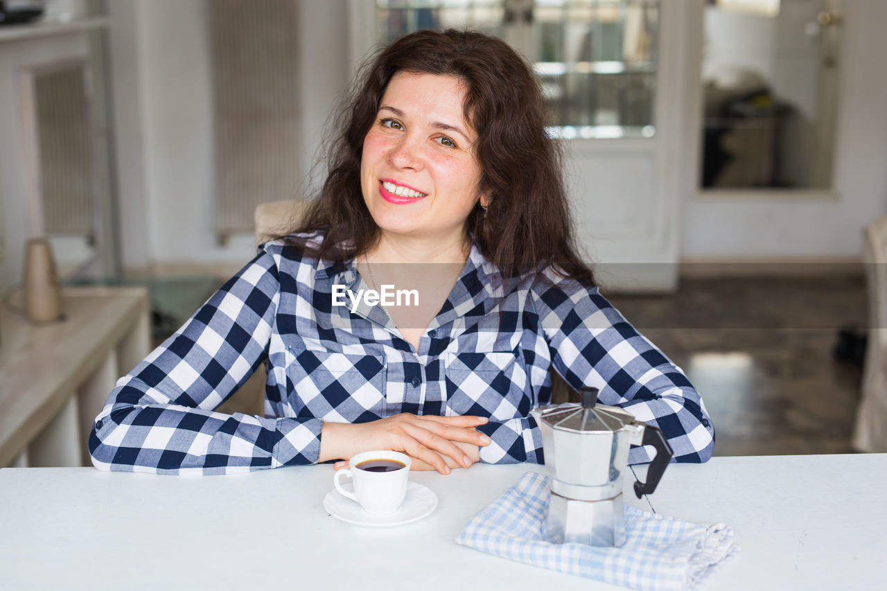 Portrait of smiling woman sitting at cafe