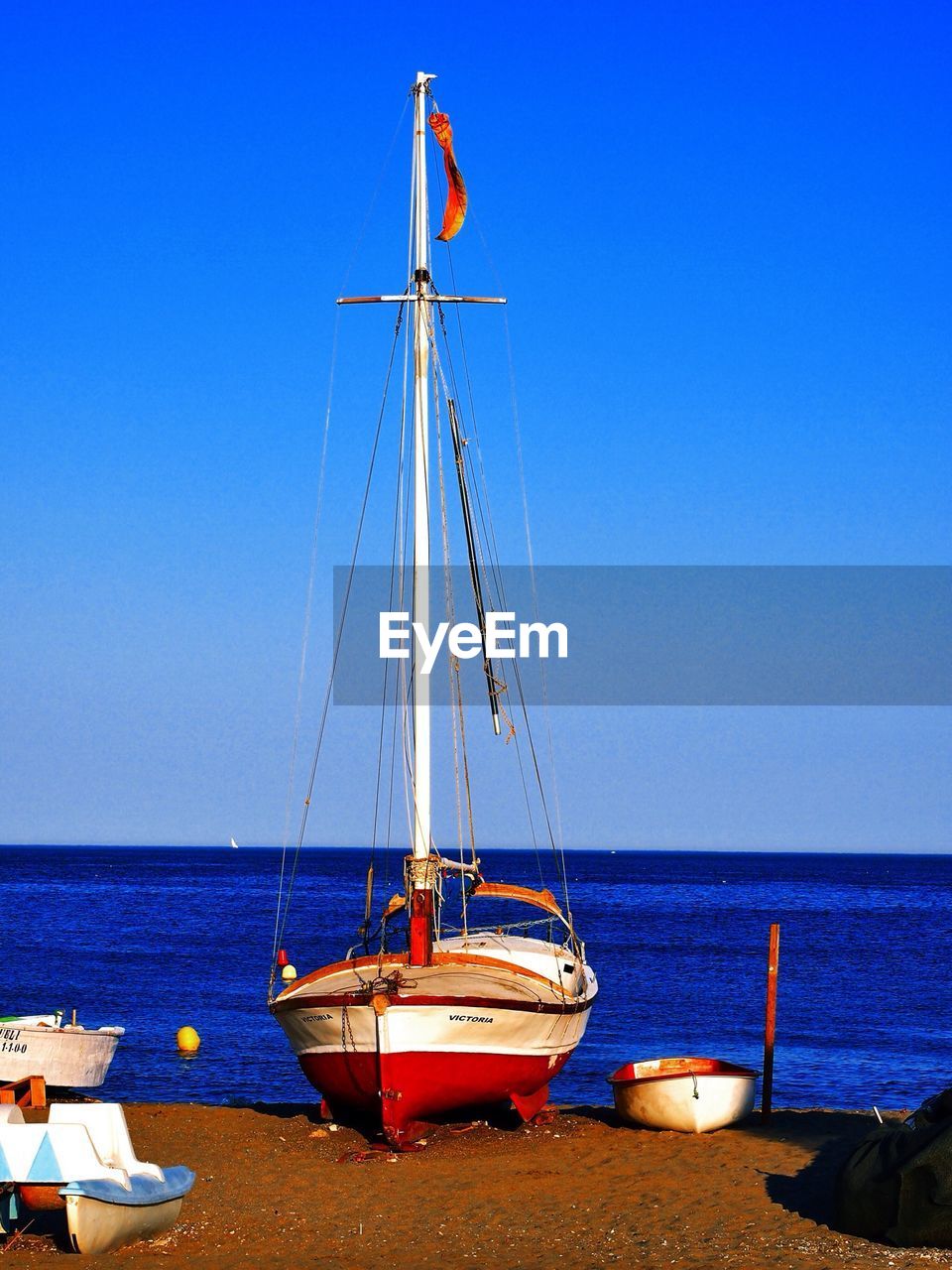 Boats moored on beach against clear sky