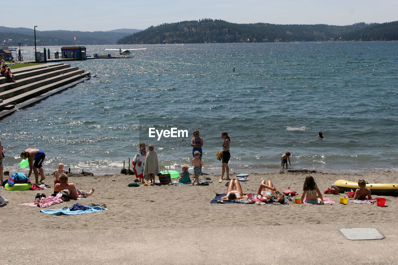 High angle view of people enjoying at beach during sunny day