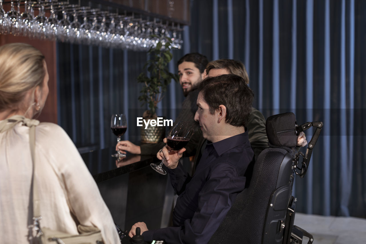 Group of friends having wine in bar