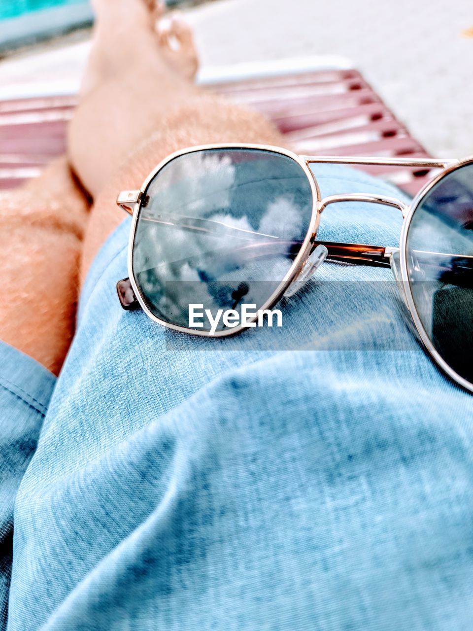 CLOSE-UP OF SUNGLASSES WITH REFLECTION OF MAN