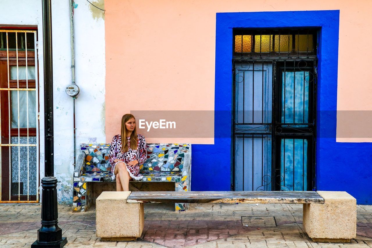 Young woman sitting outside building