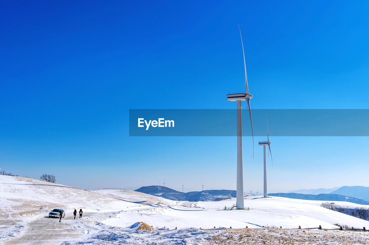 Low angle view windmill on field against sky during winter