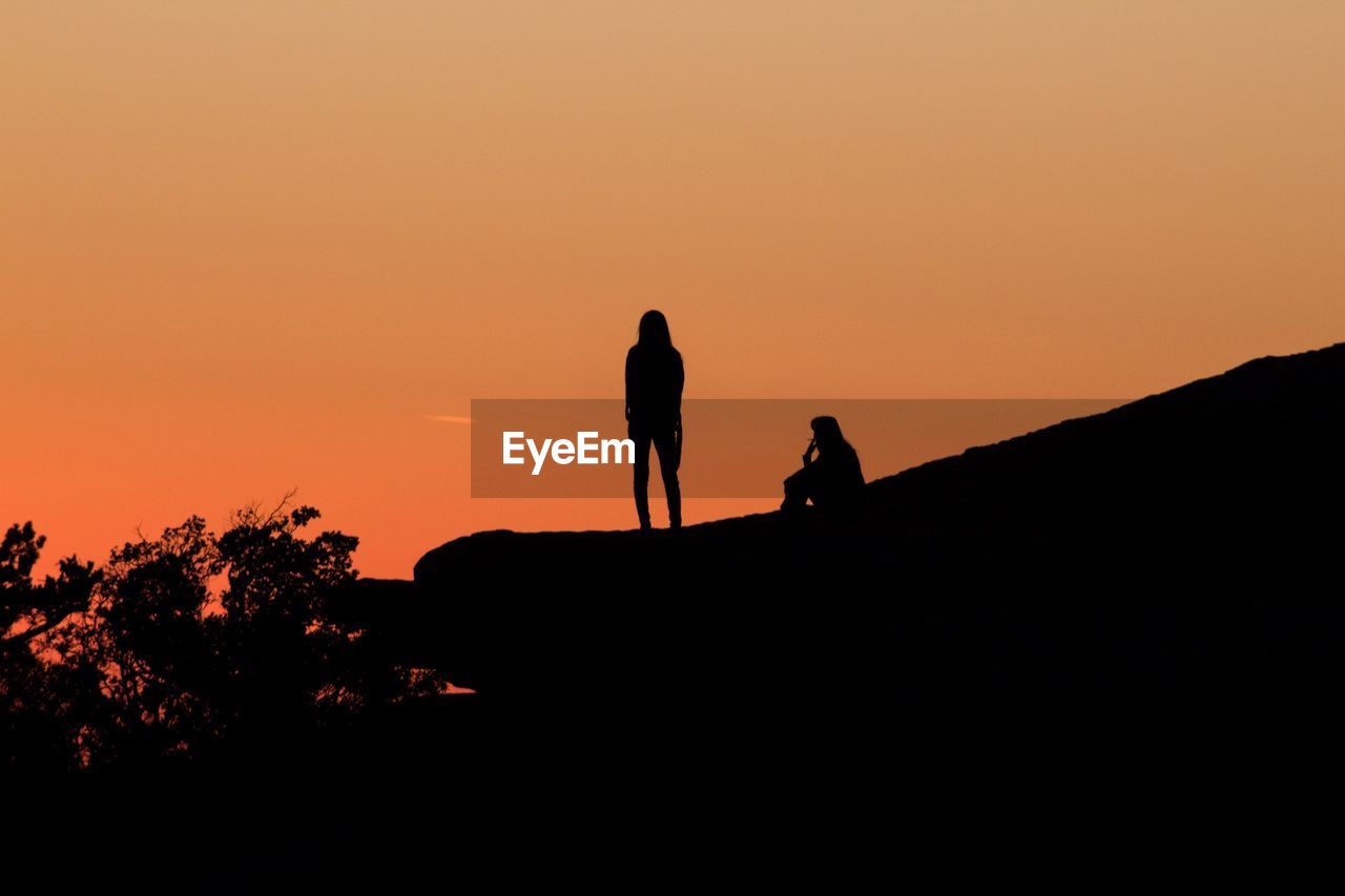 SILHOUETTE PEOPLE STANDING AGAINST CLEAR SKY DURING SUNSET