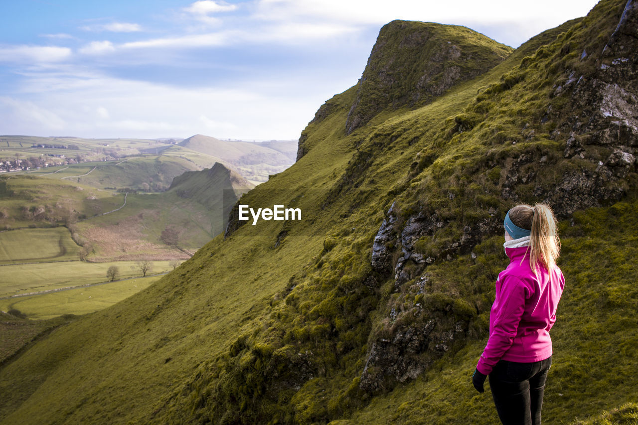 Woman looking at mountains against sky