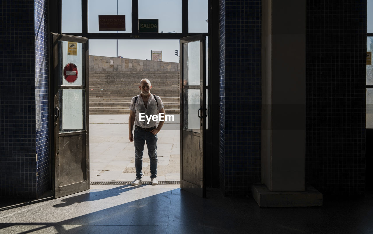 Full length of man standing at the entrance of a station in city