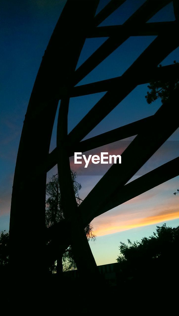 SILHOUETTE OF BRIDGE AGAINST CLOUDY SKY