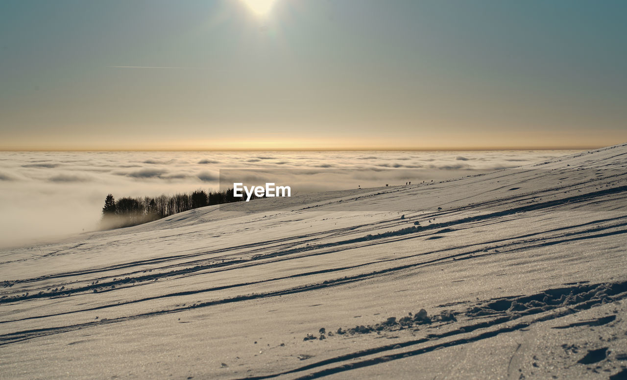 Winter in the snow walking under setting sun at sunset on the wasserkuppe mountain in hesse germany