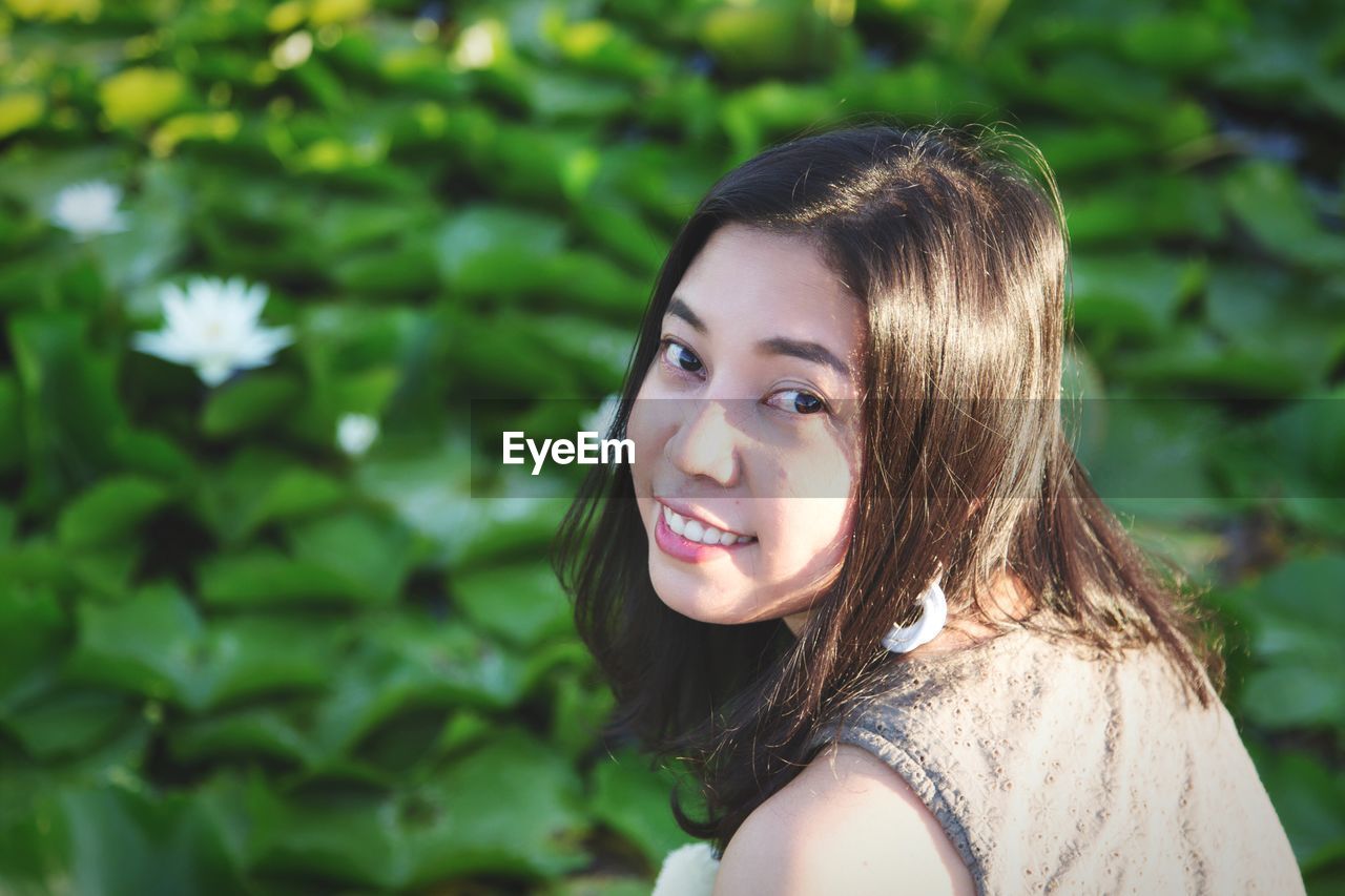 Portrait of smiling woman by lotus water lily