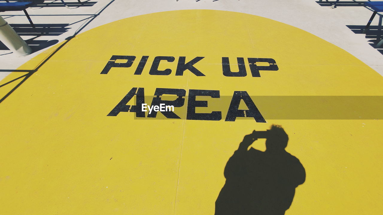 HIGH ANGLE VIEW OF TEXT ON YELLOW SIGN