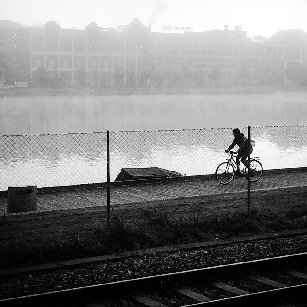 Young man cycling by river